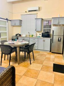 a kitchen with a table and chairs and a refrigerator at Grandvistasuites Tobago in Scarborough