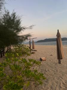 a couple of umbrellas on a sandy beach at Marinthara in Ko Phra Thong