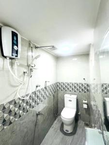 a bathroom with a toilet and a tv on the wall at Bluebell Guest House in Unawatuna +30 photos