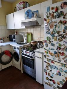 a kitchen with a stove and a refrigerator with magnets at nys willy in Grimbergen