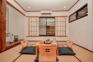 a dining room with a wooden table and chairs at Chiangrai Ryokan in Ban Long Khi Na