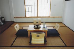 a table and chairs in a room with a window at Chiangrai Ryokan in Ban Long Khi Na