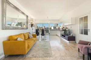 a living room with a yellow couch and a kitchen at Cherry Penthouse in Spinola Bay in St. Julianʼs