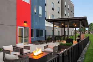 a patio with chairs and a fire pit in front of a building at avid hotel Bellefonte by IHG in Bellefonte