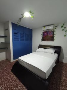 a bedroom with a large bed with a blue door at hostal portones de getsemani in Cartagena de Indias