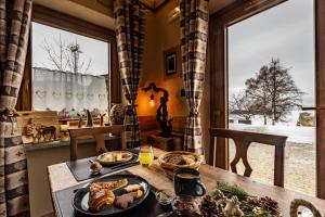a table with food on it in a room with a window at Chalet Saint-Barthélemy Hotel in Nus