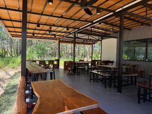 a restaurant with wooden tables and chairs and windows at Marinthara in Ko Phra Thong