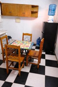 a kitchen with a table and two chairs and a refrigerator at La Petite Maison Mariano Casa in Limpio