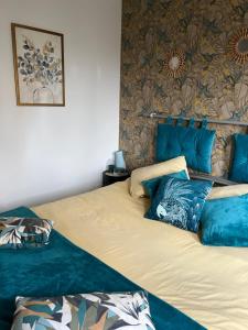 a bedroom with two beds with blue pillows at Chambre chaleureuse in Grosley-sur-Risle