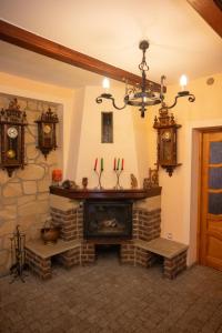 a living room with a fireplace and clocks on the wall at Góry Sowie Agroturystyka in Rzeczka +17 photos