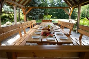 a wooden picnic table with plates of food on it at Góry Sowie Agroturystyka in Rzeczka