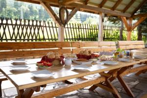 a wooden table with plates of food on it at Góry Sowie Agroturystyka in Rzeczka