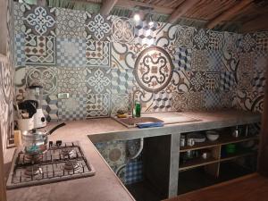 a kitchen with a stove and a counter with tiles at Sexto Sentido Cabañas & Pan Frances in Palomino