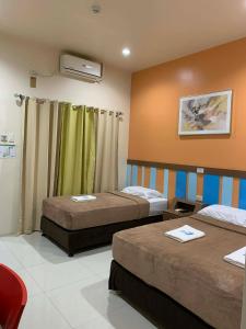 a hotel room with two beds in a room at Zion Pension House in Ozamis +28 photos