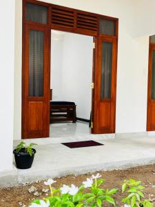 an open door of a house with a piano at Bluebell Guest House in Unawatuna