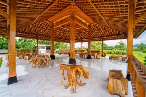 a large wooden pavilion with tables and chairs at Hotel Tiara By ARBA in Weleri