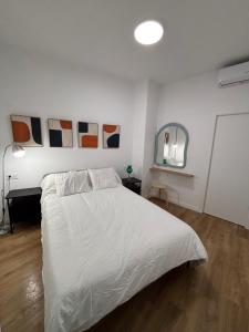 a bedroom with a white bed and a mirror at Cuatro Cantillos in Aguilar de la Frontera +2 photos