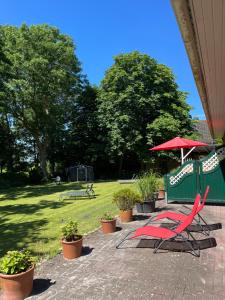 a group of chairs and an umbrella in a yard at Ferienwohnanlage Sturmhöhe in Welt