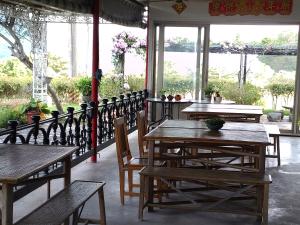 um restaurante com mesas e cadeiras de madeira e janelas em Kai Tai B&B em Yung-an-ts'un