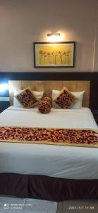 a bedroom with a large bed with pillows at Hotel Mirabel in Jajpur Road +2 photos