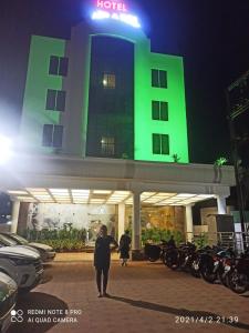 a man standing in front of a building at night at Hotel Mirabel in Jajpur Road