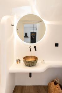 a bathroom with a sink with a mirror at ĪKADE Mykonos in Mikonos +111 photos