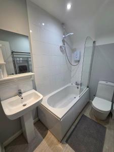 a bathroom with a sink and a tub and a toilet at 4a Smart Apartments in Newark-on-Trent