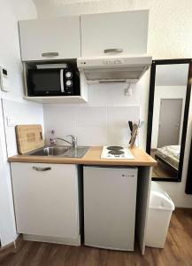 a small kitchen with a sink and a microwave at Studio avec piscine SAINT FLORENT - FLO300-259 in Saint-Florent