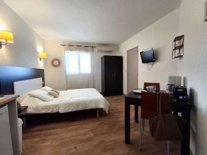 a bedroom with a bed and a desk and a table at Studio avec piscine SAINT FLORENT - FLO300-259 in Saint-Florent