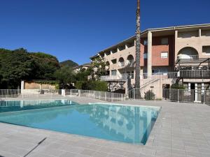 a swimming pool in front of a building at Studio avec piscine SAINT FLORENT - FLO300-259 in Saint-Florent