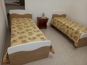 a bedroom with two beds and a night stand at Casa Roberta in Martis