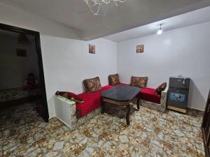 a living room with a red couch and a table at ADAGHAS studio 1,3 in Agadir