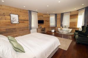 a bedroom with a bed and a bathroom with a tub at Grey Castle garnì&suite in Ponte di Legno