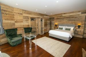 a bedroom with a bed and a wooden wall at Grey Castle garnì&suite in Ponte di Legno +99 photos
