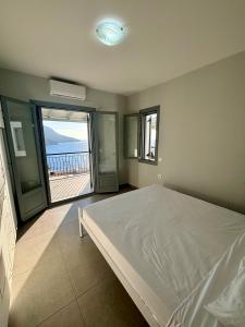 a bedroom with a bed and a view of the ocean at Three Olive Homes in Kalymnos +84 photos