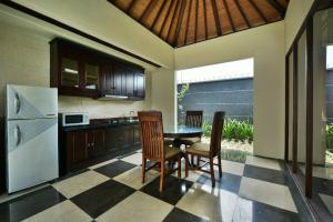 a kitchen with a table and chairs and a refrigerator at The Khayangan Dreams Villa, Seminyak in Seminyak
