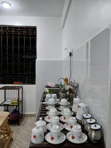 a group of white cups and saucers on a table at Hidalgo Home Apartment's in Moshi