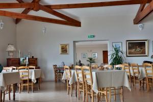 a dining room with tables and chairs and wooden ceilings at Hôtel restaurant Le Belvedere De Coti in Coti-Chiavari
