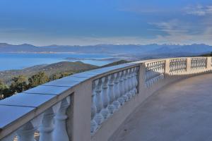 a balcony with a view of the water and mountains at Hôtel restaurant Le Belvedere De Coti in Coti-Chiavari