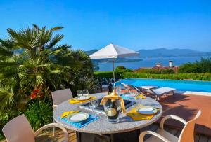 a table and chairs with a table and a pool at Villa Marta in Meina
