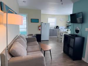 a living room with a couch and a kitchen at Drift Ashore House in Rocky Harbour