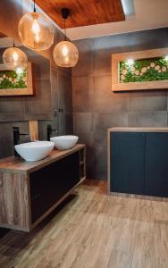 a bathroom with two sinks and two mirrors at Apartament Damian in Kamienna Góra