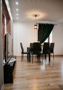 a dining room with a table and chairs and a tv at Apartament Damian in Kamienna Góra