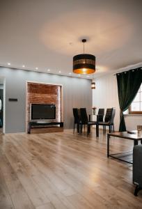 a living room with a fireplace and a table and chairs at Apartament Damian in Kamienna Góra