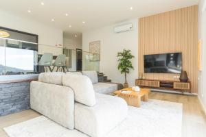 a living room with a couch and a tv at Villa Sofia by Atlantic Holiday in Machico
