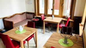 a restaurant with tables and chairs and a couch at Bio Bed & Breakfast Froschkönig in Gersau