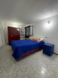a bedroom with a large bed with blue sheets at Refugio Blue Hill in Villa Cerro Azul