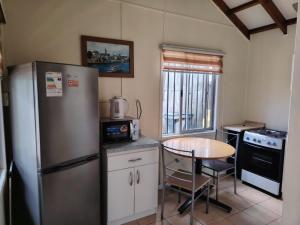 a small kitchen with a table and a refrigerator at Cabañas Arlenne in Valdivia