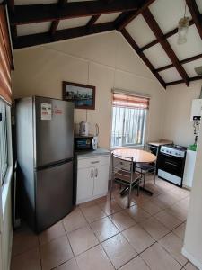 a kitchen with a stainless steel refrigerator and a table at Cabañas Arlenne in Valdivia +15 photos