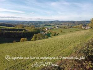 a field of green grass with a town in the distance at ArPaMond in Château-Chinon